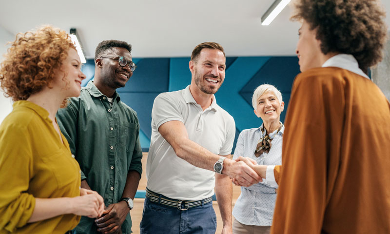 Group of office coworkers welcoming their new hire.