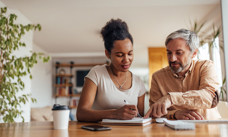 Older Married couple planning talking through retirement.